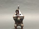 silver plated figurine of a man playing a musical instrument on a stand