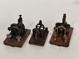 three small metal objects are sitting on top of a white surface