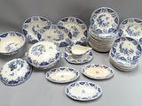 many blue and white plates and bowls on the table