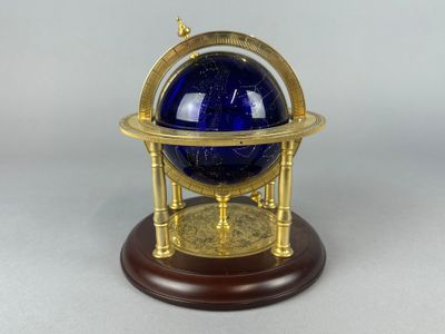 une boule de verre bleue posée sur un socle en bois