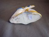 a white and yellow shoe that is on a table