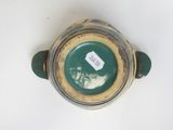 a green and yellow vase with a tag on it