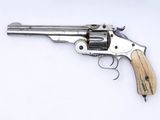 gros plan d'un revolver sur une surface blanche