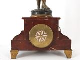 a statue of a man on a clock on a stand