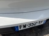 a close up of a white car with a license plate on it