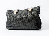 a black handbag with gold hardware on a white background