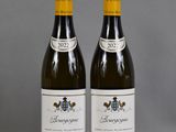 two bottles of wine sitting on top of a table next to each other