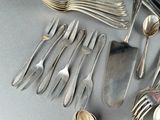 a lot of silver spoons and forks on the table