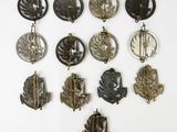 many different types of brooches hanging on a wall