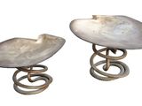 paire de tabourets blancs en forme de coquillage, avec des pieds en spirale, sur fond blanc