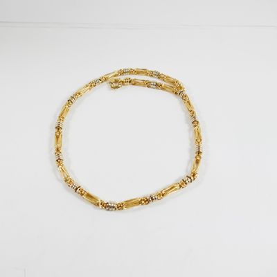 un bracelet en or sur une surface blanche