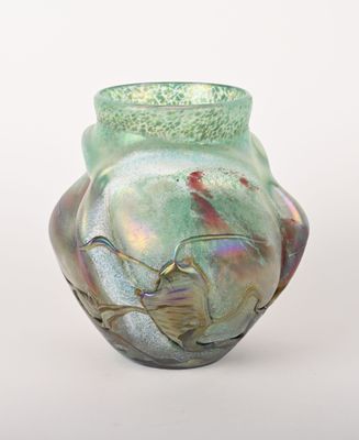 un vase vert orné d'un oiseau, posé sur une table