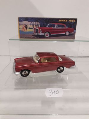 a red toy car on display in a glass case