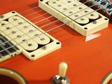 an orange electric guitar sitting on top of a white table