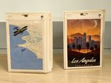 two luggage tags on a table with a picture of a plane
