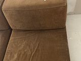 brown corded chair and ottoman in a room with a white wall