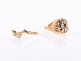 two gold rings with diamonds on them sitting next to each other