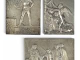 four silver metal plaques depicting a woman and a man with a sword