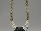 an image of a necklace made out of shells on a stand