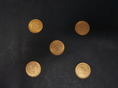 four gold coins are arranged in a circle on a black surface