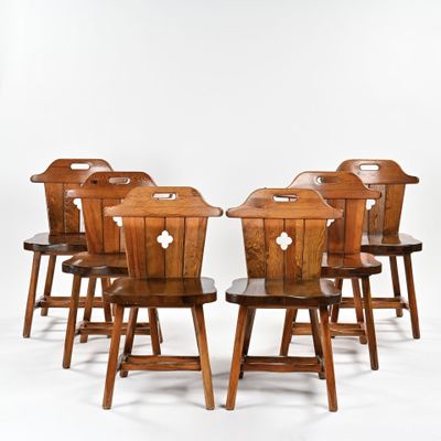 six wooden chairs sitting in a row on a white surface