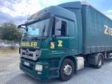 un camion vert garé sur un parking