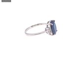 a close up of a diamond and sapphire ring on a white background