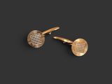 a pair of gold cufflinks on a black background