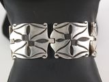 un gros plan d'un bracelet en argent posé sur un coussin noir