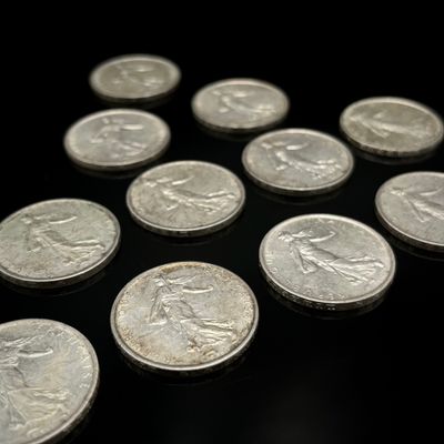 quelques pièces d'argent sont disposées en triangle sur une surface noire