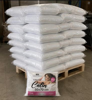une pile d'oreillers posée sur une palette dans un entrepôt