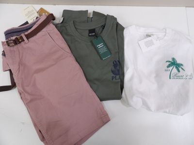 three pairs of shorts and a t - shirt sitting on a table