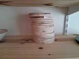 a stack of wooden bowls sitting on a wooden shelf
