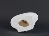 a white object with a hole in it on a black surface
