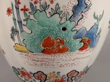 a close up of a vase with a fish and flowers on it