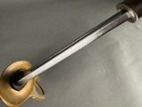 a metal object with a long handle on a table