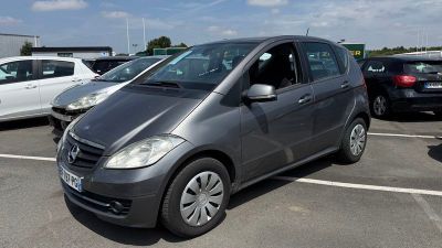 Une Mercedes Classe B garée sur un parking, avec d'autres voitures en arrière-plan