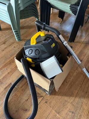 un aspirateur posé dans un carton par terre