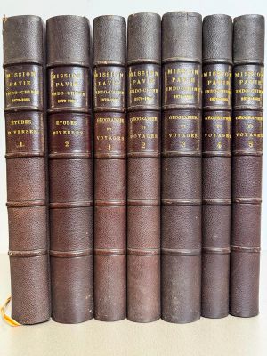 several old books are lined up on a white surface