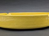 yellow glazed bowl on grey background with black background