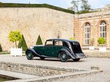 a vintage car parked in front of a stone building