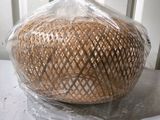un panier de pain emballé dans du plastique posé sur une table