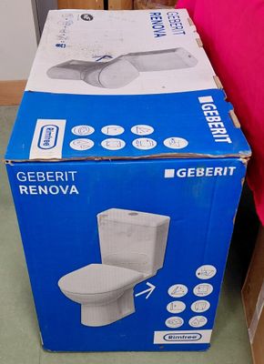 une boîte posée par terre à côté des toilettes