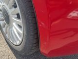 a close up of a red car ' s tire on the road