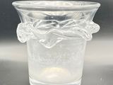 a clear glass vase with a flower design on it