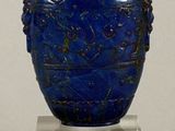 a blue vase with a lid sitting on a clear stand