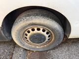 a dirty tire on the side of a white car