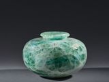 une photo d'un vase en verre vert sur fond noir