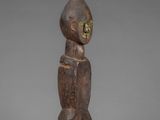 a wooden statue of a man with a hat on his head
