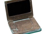 an old laptop with a broken screen sitting on a white surface